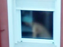 Nude titted female is seen on window voyeur video