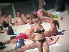 Voyeur on the beach capturing a tanned and naked girl